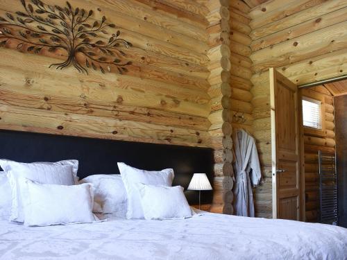 a bedroom with a bed with a wooden wall at Mayfields Retreat in Newsham