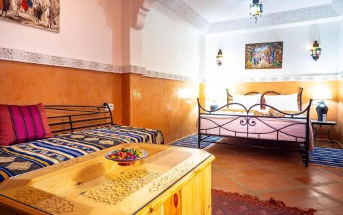 un salon avec deux lits et une table dans l'établissement RIAD BIEN ICI, à Marrakech