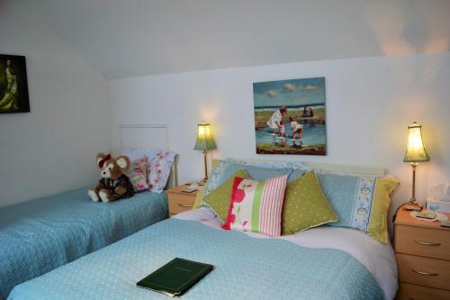 a bedroom with two beds and a teddy bear sitting on the bed at Killyliss Country House B&B in Lisnalong