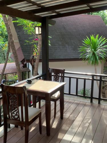patio con tavolo e sedie su una terrazza di บ้านธานี (BAAN THANI) a Choeng Mon Beach