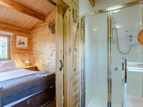 ein Schlafzimmer mit Dusche und ein Bett in einem Zimmer in der Unterkunft Buttercup Lodge in Broomhill
