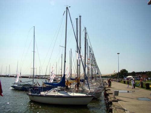 a group of sailboats docked at a dock in the water at Apartamentai Dorė in Nida