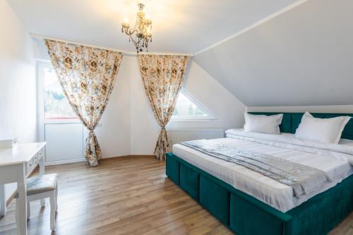 a bedroom with a bed and a desk and a window at On the Hill in Braşov