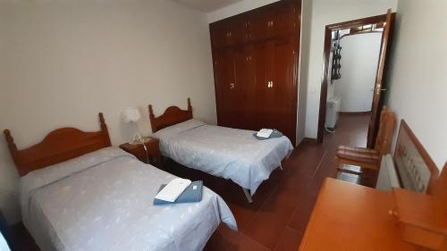 Habitación de hotel con 2 camas y espejo en La casa de Pi, en Torrecaballeros