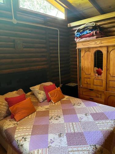 1 dormitorio con cama y tocador de madera en Cabañas mateo en Balneario Mar Azul