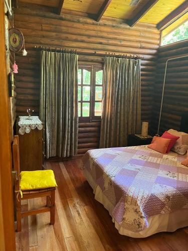 1 dormitorio con 1 cama en una cabaña de madera en Cabañas mateo en Balneario Mar Azul