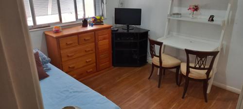 1 dormitorio con 1 cama, mesa y sillas en Coração de Ipanema, en Río de Janeiro