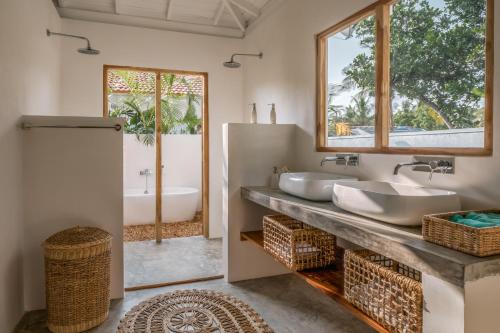ein Badezimmer mit zwei Waschbecken und einer Badewanne in der Unterkunft Panta Rei resort in Ahangama