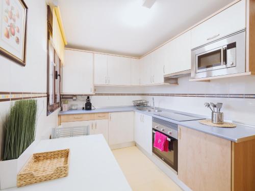 a kitchen with white cabinets and a counter top at Apartamento "MACHOTE" in Tordesillas