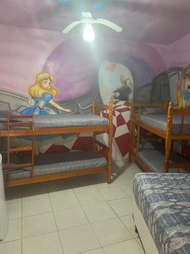 a room with two bunk beds and a mural at Colônia Virtual Net in Itanhaém