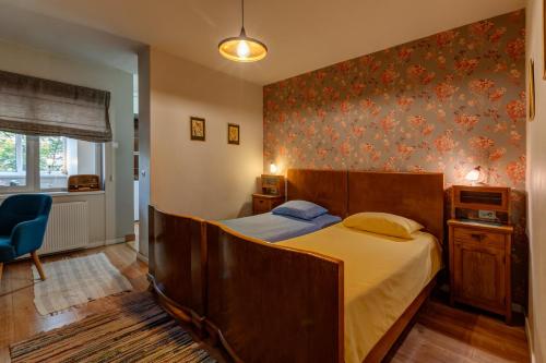 um quarto com uma cama grande e uma cadeira azul em Cool Opera Apartments em Cluj-Napoca
