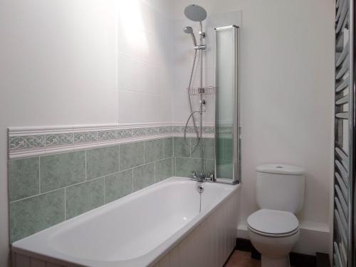 a bathroom with a white tub and a toilet at Sparrow in Burton Bradstock