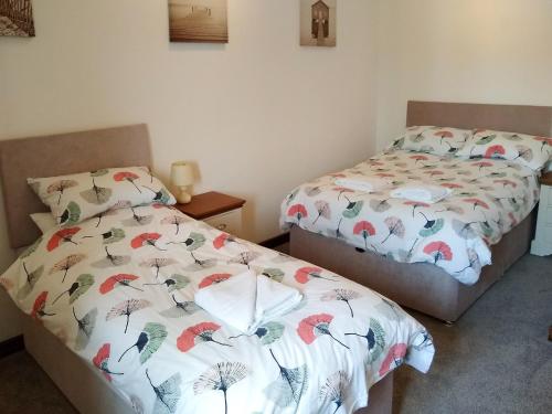 two beds sitting next to each other in a bedroom at Sparrow in Burton Bradstock