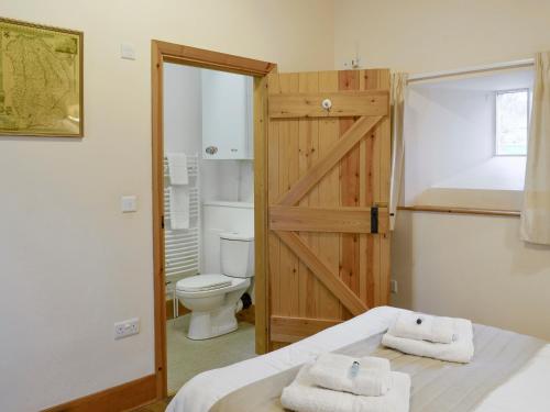 - Baño con aseo y cama con toallas en The Old Dairy - 26726, en North Willingham