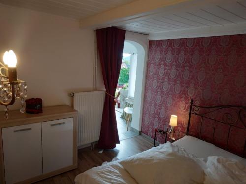 een slaapkamer met een bed en een rode muur bij Ferienwohnung Pirna-Panorama in Pirna