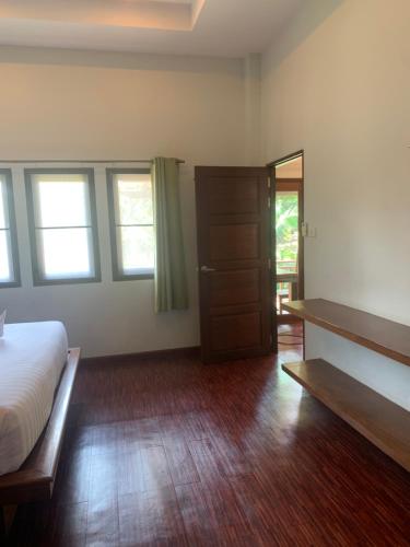 a bedroom with a bed and a closet and a door at บ้านธานี (BAAN THANI) in Choeng Mon Beach