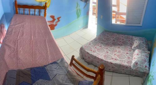 a bedroom with two beds and a bunk bed at Colônia Virtual Net in Itanhaém
