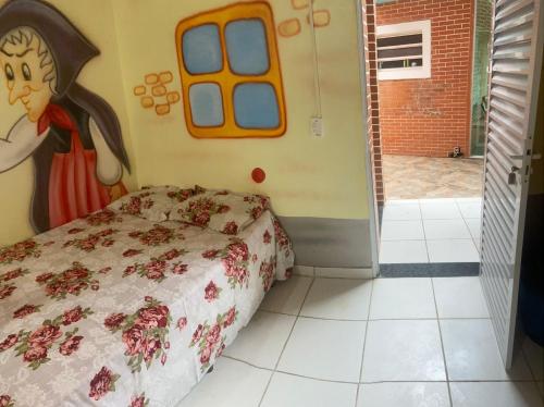 a bedroom with a bed and a door to a courtyard at Colônia Virtual Net in Itanhaém
