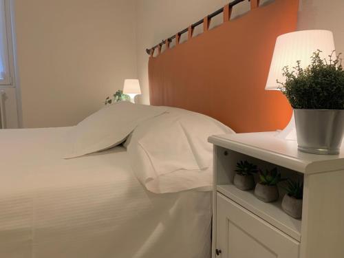 a bed with a white pillow and a table with a lamp at Mamma Ciccia in Mandello del Lario
