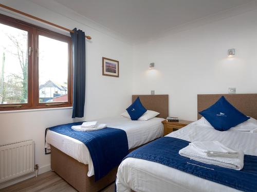 a hotel room with two beds and a window at Heron in Wroxham