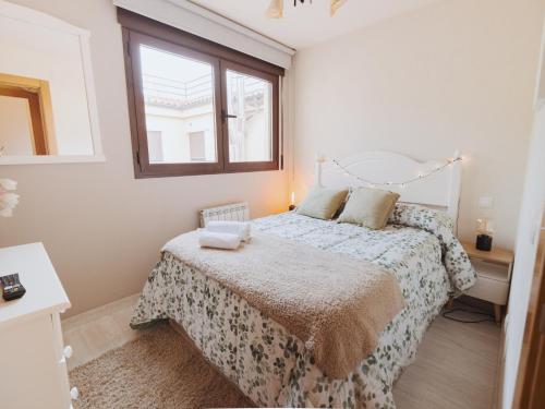 a bedroom with a bed and a window at Apartamento "RASCALINDES" in Tordesillas