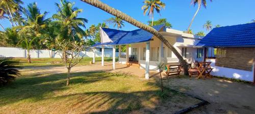 a house with a blue roof and a patio at Marari Sailor Homes in Shertallai