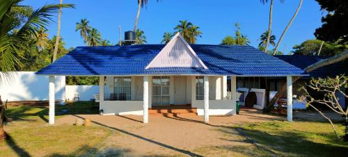 uma pequena casa com um telhado azul em Marari Sailor Homes em Shertallai