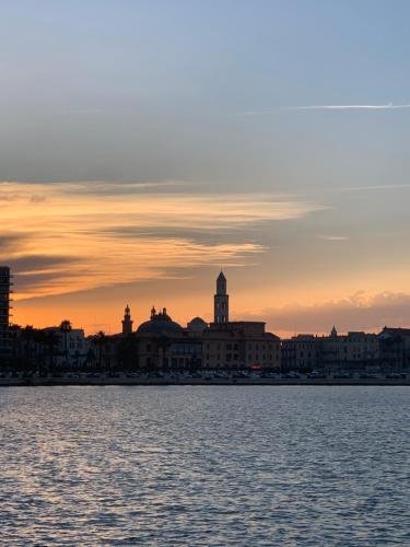 a view of a city from the water at sunset at Porto Antico in Bari
