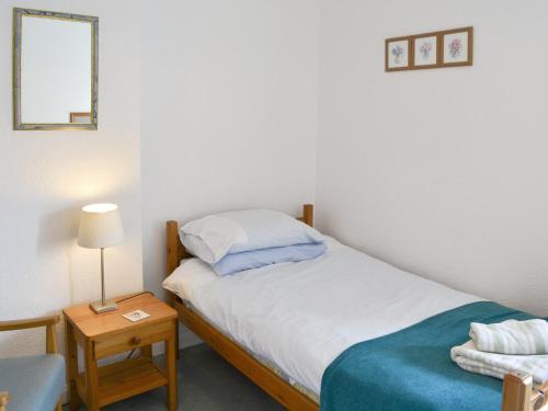 Dormitorio pequeño con cama y mesa con lámpara en Cheviot View, en Alnwick