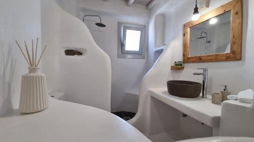 a white bathroom with a sink and a mirror at Antheia Suite of Mykonos in Ano Mera