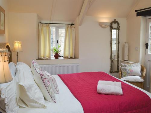 a bedroom with a large bed with a red blanket at Meadow Mews in Stokenham