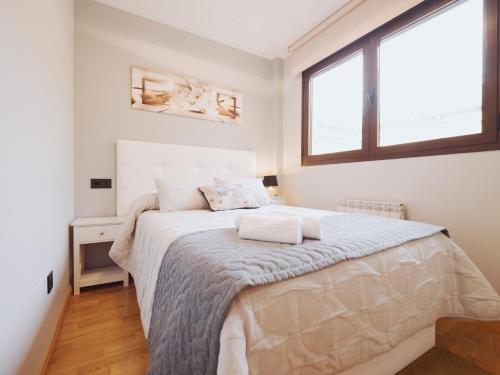 una camera bianca con un grande letto con due cuscini di Apartamento BENITA a Tordesillas