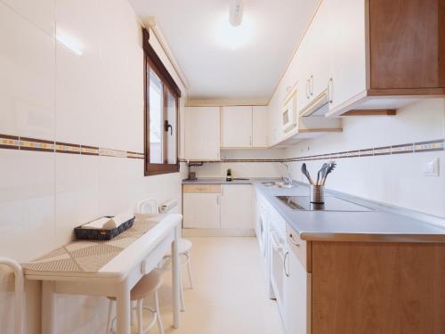 una cucina con armadi bianchi e un tavolo di Apartamento BENITA a Tordesillas