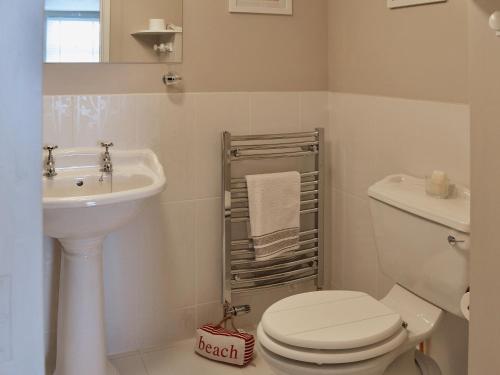 a white bathroom with a toilet and a sink at Waterside in Fowey