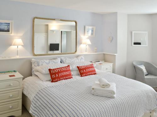a bedroom with a bed with two pillows and a mirror at Waterside in Fowey