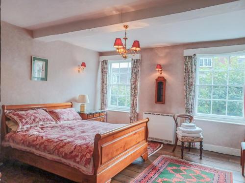 a bedroom with a bed and two windows at Ellinor House in Cleobury Mortimer