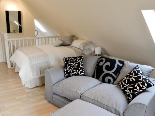 a living room with a couch and a bed at The Studio in Warkworth