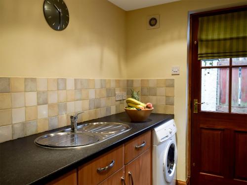 a kitchen with a sink and a bowl of bananas at The Bothy in Glendevon