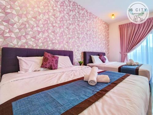 two beds in a room with pink and purple wallpaper at Pangsapuri Meridian by RR JBcity in Nusajaya