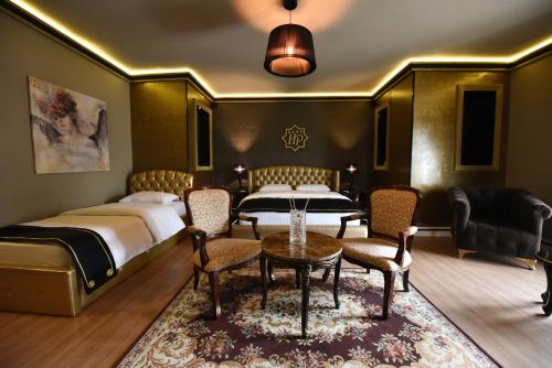 a bedroom with two beds and a table and chairs at Hotel Hymeti's Palace in Pogradec