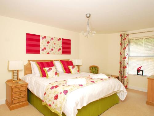 a bedroom with a large bed with red pillows at Tree Tops - A4 Masts in Torquay