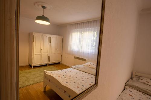 een spiegel die een slaapkamer met een bed en een raam weerspiegelt bij City Block Apartment in Pristina