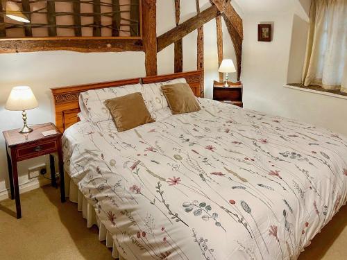 Schlafzimmer mit einem großen Bett mit einem Kopfteil aus Holz in der Unterkunft Oddwell Cottage in Brompton Ralph