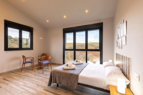 Un dormitorio con una cama y una mesa y sillas. en Erretola - Baskey Rentals, en Aizarnazábal