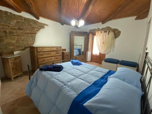 a bedroom with a large bed and a stone wall at Casa Vacanze Maja e Ermes in Arsita