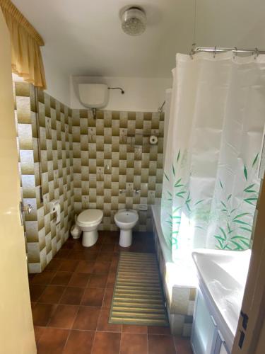 a bathroom with two toilets and a tub and a sink at Casa Vacanze Maja e Ermes in Arsita