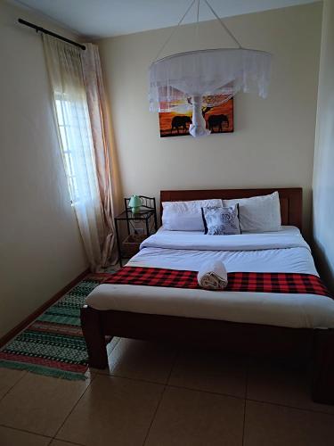 a bedroom with a bed with a checkered blanket at Nests by Too in Eldoret