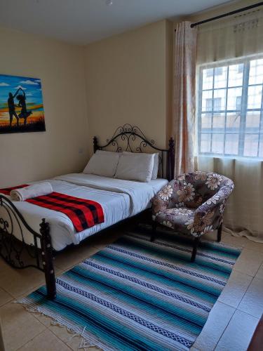 ein Schlafzimmer mit einem Bett, einem Stuhl und einem Fenster in der Unterkunft Nests by Too in Eldoret