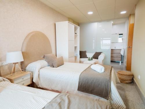 um quarto com duas camas e um sofá em Apartamento "CAMPO CARMEN" nas Tordesilhas