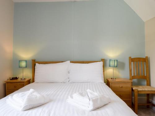 ein Schlafzimmer mit einem Bett mit zwei weißen Handtüchern darauf in der Unterkunft Millies Cottage in Keswick